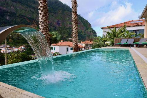 a pool with a water fountain in a resort at Quinta dos Cardais by AnaLodges in São Vicente