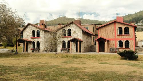 une ancienne maison en pierre avec une tourelle rouge dans l'établissement Hotel Real de San Antonio, à Estanzuela