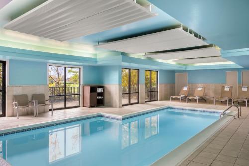 a pool in a hotel room with tables and chairs at SpringHill Suites by Marriott Chicago Bolingbrook in Bolingbrook
