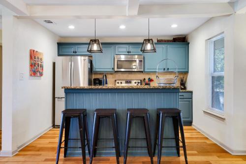 a kitchen with blue cabinets and bar stools at Richters Garage - A Birdy Vacation Rental in Boerne