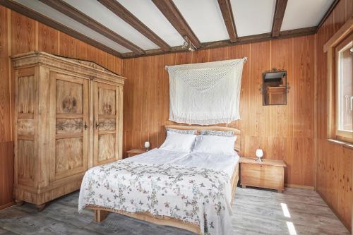 ein Schlafzimmer mit einem Bett und einer Holzwand in der Unterkunft Casa Bubeck in Cavagnago