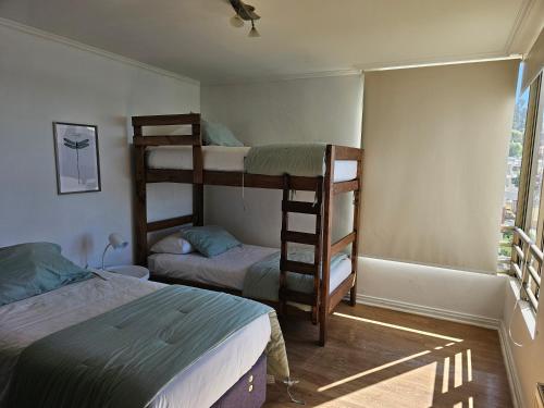 a bedroom with two bunk beds and a window at Espectacular Bahía Bonita depto 21 in Concón