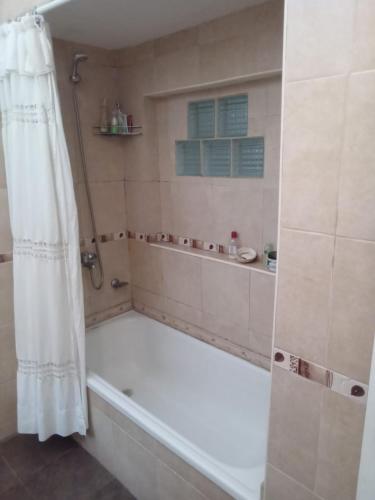 a bathroom with a tub and a shower curtain at DAS THOMY II in Córdoba