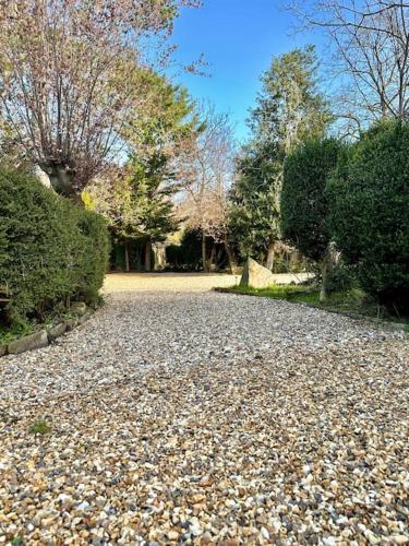 a gravel road with trees and bushes in a park at Historic Charm: *Perfect For Group Getaways* in Trowbridge