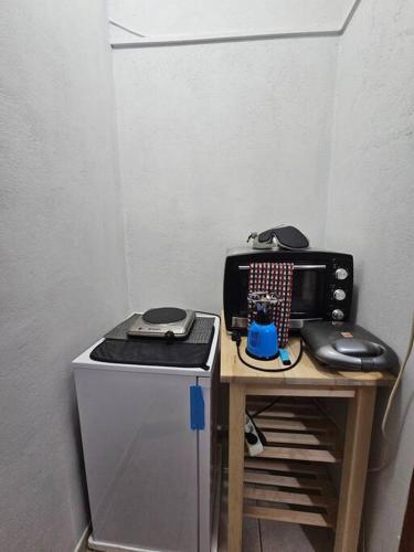 a small table with a microwave and a mouse at Μεγάλος χώρος με Γυμναστήριο-Χαμάμ-Κρεβάτι-Γραφείο in Krionérion