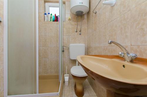 een badkamer met een wastafel, een toilet en een douche bij House Andelka in Supetar