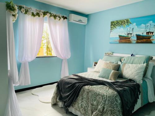 a blue bedroom with a bed and a window at Villa Paradise in Brazil - Praia de Guaratiba Prado-BA in Prado