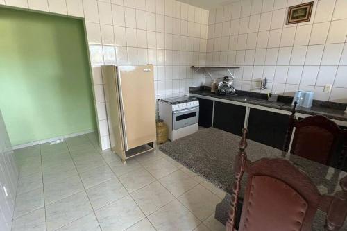 uma cozinha com um frigorífico e um fogão em Apartamento em Setiba em Guarapari