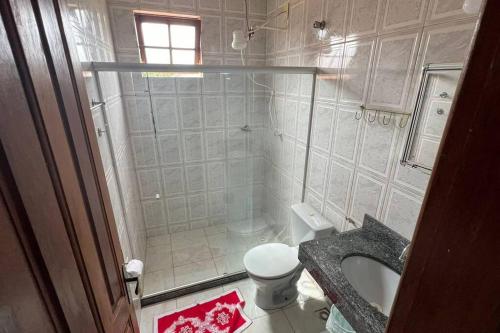 uma casa de banho com um chuveiro, um WC e um lavatório. em Apartamento em Setiba em Guarapari