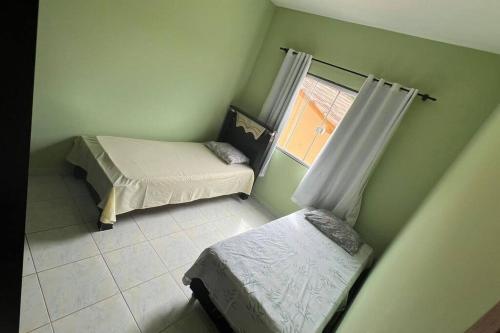 ガラパリにあるApartamento em Setibaのベッド2台と窓が備わる小さな客室です。