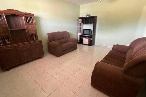 Apartamento em Setiba في غواراباري: غرفة معيشة مع أريكة وكرسي