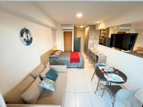 um pequeno quarto com uma cama e um sofá em Muro Alto-Porto de Galinhas Flat Makia 104D em Ipojuca