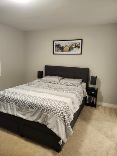 - une chambre dotée d'un grand lit avec un cadre noir dans l'établissement Brand New-Budget friendly master bedroom-House, à Carleton Place