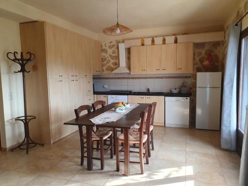 a kitchen with a table and chairs and a refrigerator at cottage du soleil in Makry Gialos