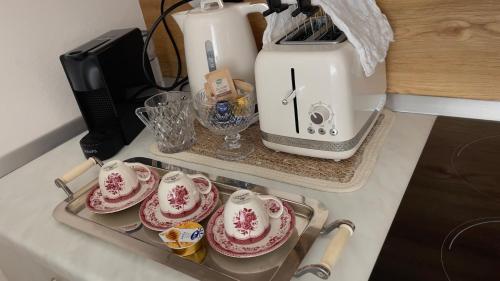 a kitchen counter with a toaster and plates on a tray at La ROMANTICA VERONA in Verona