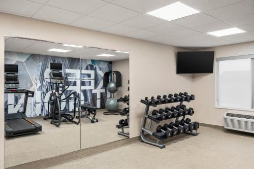a fitness room with tread machines and a tv at SpringHill Suites by Marriott Chicago Bolingbrook in Bolingbrook
