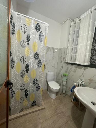 a bathroom with a toilet and a shower curtain at Kleidi's home in Vlorë