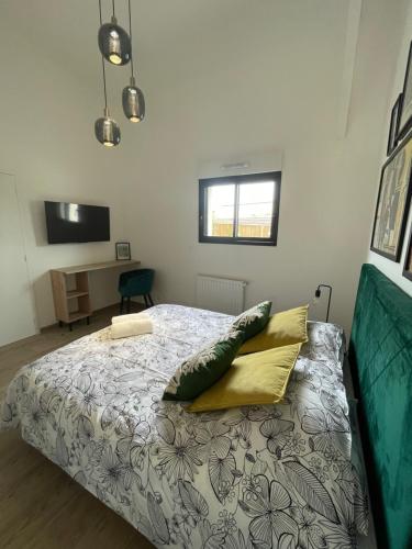 a bedroom with a bed with pillows on it at Résidence Tamaris Loft House in La Mézière