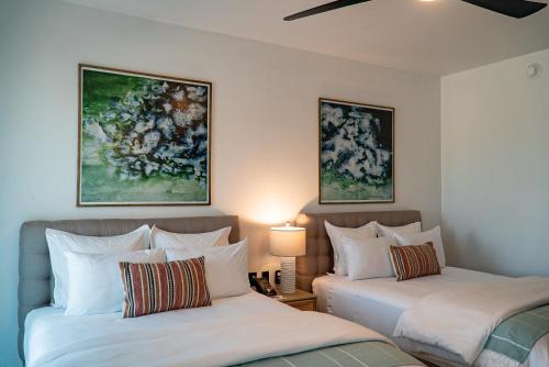 duas camas num quarto com pinturas na parede em Flamboyan Hotel & Residences em San José del Cabo