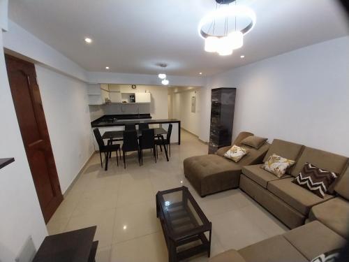 ein Wohnzimmer und eine Küche mit einem Sofa und einem Tisch in der Unterkunft Edificio parque residencial in Lima