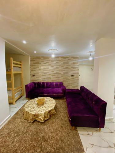 a living room with a purple couch and a table at Apartement au Bord de la Mer TOURMA in Taghazout