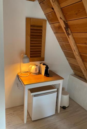 a small white table with a tea kettle on it at Zilverzoen Slapen in Elburg