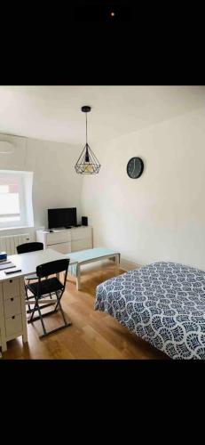 a bedroom with a bed and a desk and a chair at Studio tout confort cité de la gastronomie (4) in Dijon