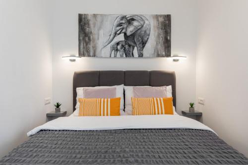 a bedroom with a bed with an elephant painting on the wall at Apartment Karla in Split