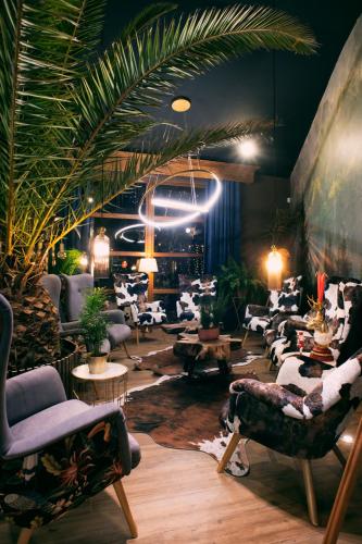a room with a bunch of chairs and plants at Hotel Kotarz Spa&Wellness in Brenna