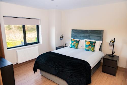 una camera con un grande letto e una finestra di The Village Inn a Killarney