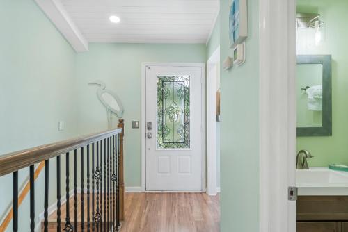 a hallway with a white door with a stained glass window at Solitude on 30A - Seacrest Beach Townhouse with Beach Access - FREE BIKES in Rosemary Beach
