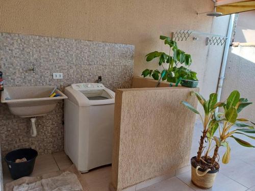 a bathroom with a toilet and a sink and plants at Sobrado charmoso em localização central! in Sorocaba
