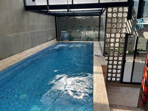 a large swimming pool with blue water in a building at Acogedor apartamento con piscina en Bogotá in Bogotá