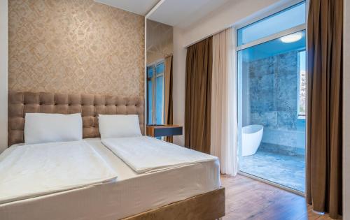a bedroom with a bed and a large window at Olympus Hotel By Umbrella in Tbilisi City