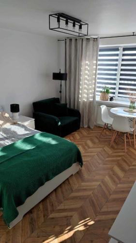 a bedroom with a green bed and a living room at Apartamenty Urban Concept in Zamość
