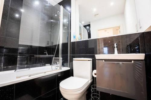 a black and white bathroom with a toilet and a sink at Cosy 2 Bed Apartment, East Croydon in Croydon