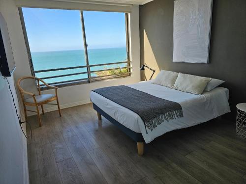 a bedroom with a bed with a view of the ocean at Espectacular Bahía Bonita depto 41 in Concón