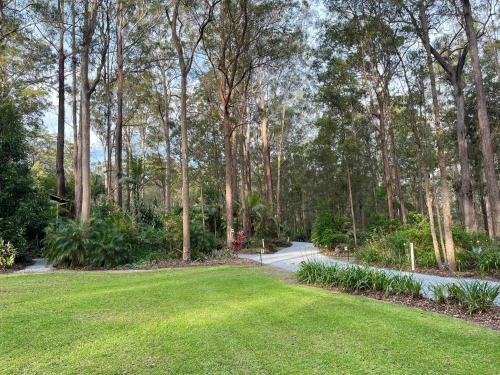 a park with a lawn and trees and a path at Chiltern Lodge Country Retreat in Old Bar