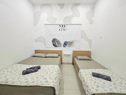 - 2 lits dans une chambre avec des chaussures sur le mur dans l'établissement Air-home No 28 Simpang near Aulong Econsave, 3BR, 7pax, Netflix, à Simpang