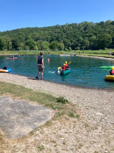 a man and a group of people in kayaks on a lake at Honey Bee Cabin in Llandysul