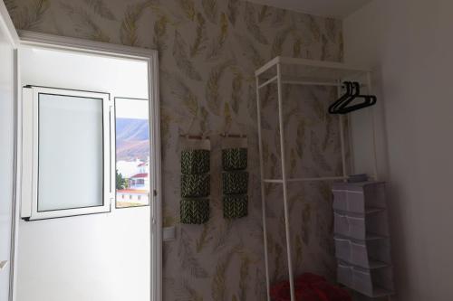 a room with a wall with a window and a shelf at Los Arenales Agaete in Agaete