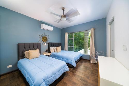 ポトレロにあるCondo Casa Blanca 7 - NEW 2 BR condo, near to the beachの青い壁の部屋にベッドが2つある