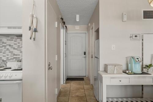 a kitchen with a hallway with a white door at Top of the Gulf 508 - Beach Front Resort Partial Ocean View in Panama City Beach