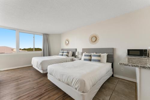 a hotel room with two beds and a television at Top of the Gulf 508 - Beach Front Resort Partial Ocean View in Panama City Beach
