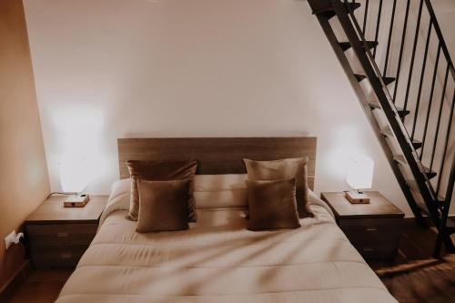 una camera da letto con un letto con due tavoli e una scala di Appartamento - Grammichele Privitera rooms & apartments Gold a Grammichele