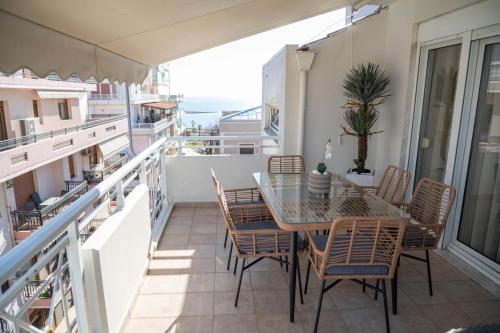 a patio with a table and chairs on a balcony at SeaView Luxury Suite in Alexandroupoli