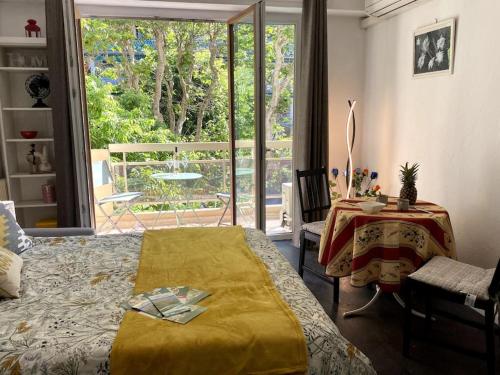 une chambre avec un lit, une table et une fenêtre dans l'établissement Studio balcon, centre ville, proximité plages, commerces, restaurants, musées..., à Antibes