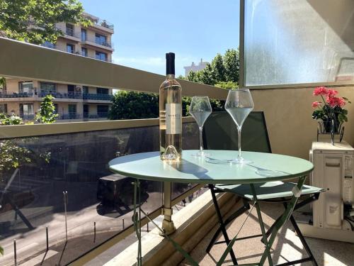 - une table avec 2 verres à vin et une bouteille sur le balcon dans l'établissement Studio balcon, centre ville, proximité plages, commerces, restaurants, musées..., à Antibes