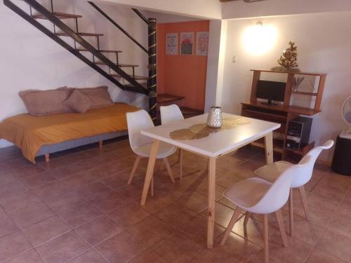a room with a bed and a table and chairs at Hermosa Cabaña Duplex Malargüe. in Malargüe