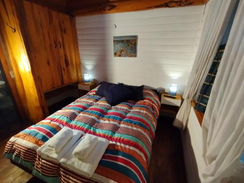 a bedroom with a bed with towels on it at Home Casa Julio in Villa La Angostura